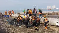 Petugas kebersihan mengangkat sampah dari Teluk Jakarta