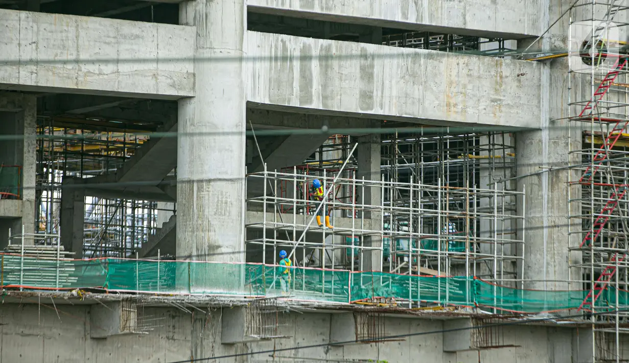 Aktivitas pekerja proyek pembangunan Jakarta International Stadium atau Stadion BMW di kawasan Papanggo, Tanjung Priok, Jakarta, Senin (18/1/2021). Progres pembangunan Jakarta International Stadium atau Stadion BMW ditargetkan rampung pada Oktober 2021. (Liputan6.com/Faizal Fanani)