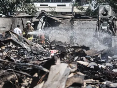 Petugas pemadam melakukan proses pendinginan di lokasi kebakaran Pasar Cempaka Putih, Jakarta, Kamis (24/9/2020). Kebakaran yang diduga akibat ledakan tabung gas dari lapak potong ayam tersebut menghanguskan 807 kios dengan kerugian ditaksir mencapai Rp 9 miliar. (merdeka.com/Iqbal S. Nugroho)