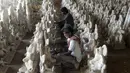 Para perajin menyelesaikan pembuatan patung Dewa Ganesha di sebuah bengkel di pinggiran Hyderabad, India, Senin (29/6/2020). Patung Dewa Ganesha banyak ditemukan di berbagai penjuru India termasuk Nepal, Tibet, dan Asia Tenggara. (NOAH SEELAM/AFP)