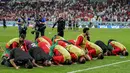 Para pemain Maroko melakukan selebrasi sujud syukur usai menaklukkan Spanyol pada laga 16 besar Piala Dunia 2022 di Stadion Education City, Selasa (6/12/2022). (AP/Martin Meissner)