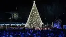 Presiden AS, Donald Trump dan ibu negara Melania Trump menghadiri upacara penerangan pohon cemara, yang menjadi Pohon Natal Nasional di taman sebelah selatan Gedung Putih, Kamis (5/12/2019). Pohon Natal Nasional tahun ini adalah cemara biru segar dari Colorado. (Brendan Smialowski / AFP)