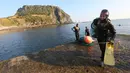 Haenyeo Korea Selatan keluar dari air setelah menangkap kerang dan abalone di pulau Jeju, 23 November 2018. Menyelam kurang lebih sampai kedalaman 20 meter, para perempuan perkasa ini tidak menggunakan tabung oksigen. (AP/Ahn Young-joon)