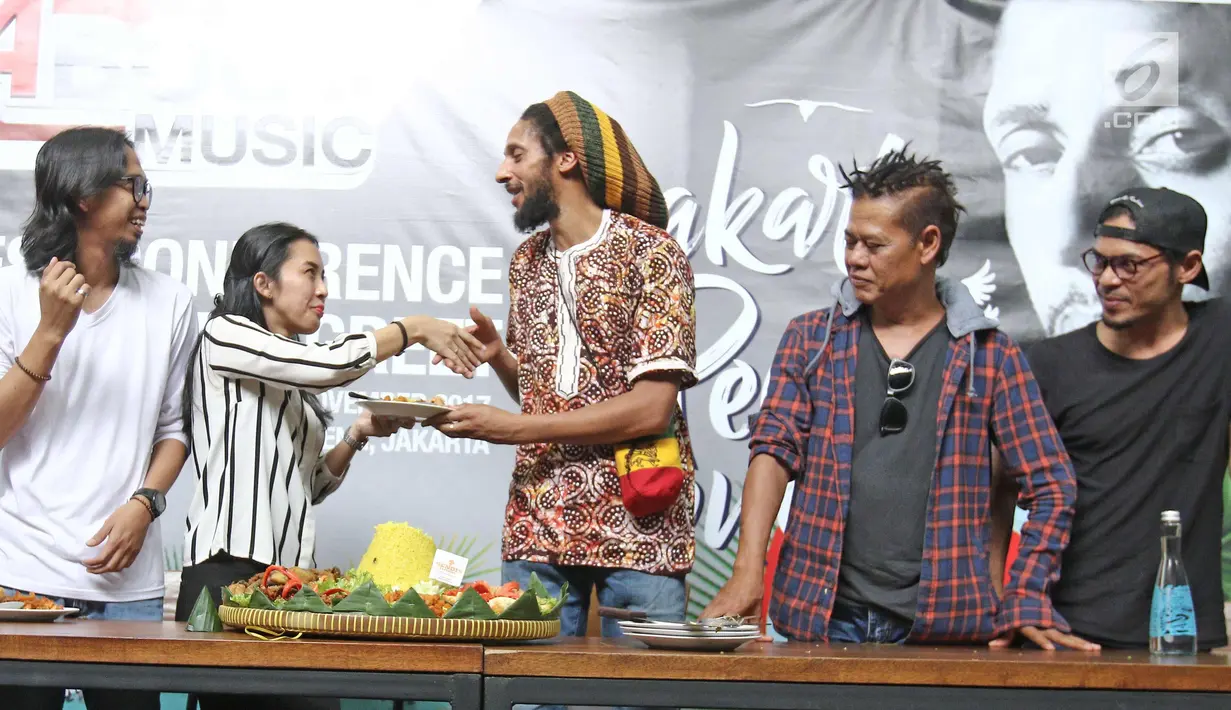 Putra Bob Marley, Julian Marley menerima potongan tumpeng sebagai tanda syukuran Jakarta Peace Concert 2017 di Jakarta, Rabu (15/11). Pada 18 November 2017, Julian Marley akan manggung di Jakarta. (Liputan6.com/Herman Zakharia)