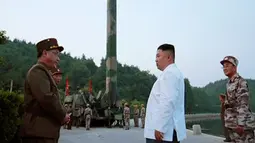 Kim Jong-un berada di lokasi uji coba peluncuran rudal balistik di Korea Utara, Selasa (30/5). Uji coba balistik yang berlangsung sukses ini diklaim telah menggunakan sistem kendali yang lebih akurat. (AP Photo/KCNA)