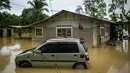 Sebuah mobil terendam banjir di Sementeh, dekat Lanchang di negara bagian Pahang Malaysia (6/1/2021). Hujan deras terus melanda sebagian wilayah Malaysia, menyebabkan ribuan orang dievakuasi di negara bagian selatan Johor dan beberapa bagian jalan raya Pantai Timur di Pahang. (AFP/Mohd Rasfan)