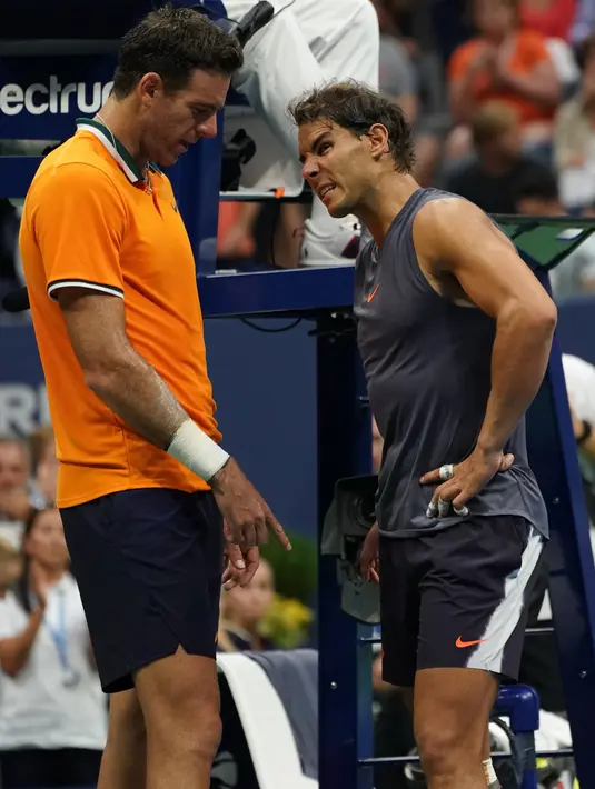 Petenis Spanyol, Rafael Nadal berbincang dengan Juan Martin del Potro dari Argentina setelah mengundurkan diri pada laga semifinal AS Terbuka 2018, Jumat (7/9). Nadal tak mampu melanjutkan pertandingan disebabkan cedera lutut. (AFP/kena betancur)