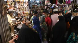 Pedagang melayani pembeli di sebuah pasar di Lahore, Pakistan (4/5/2021). Di tengah pandemi virus corona Covid-19, sejumlah warga memadati area pasar tersebut menjelang hari Idul Fitri. (AFP/Arif Ali)