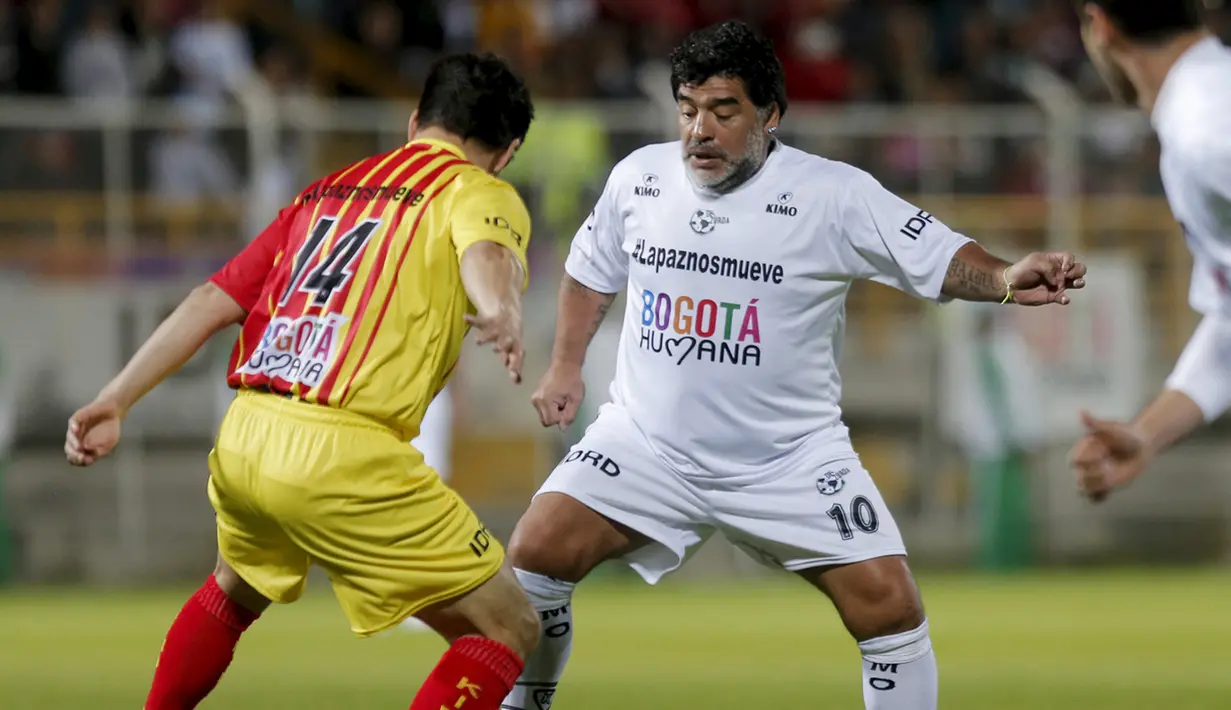 Mantan pemain Argentina, Diego Armando Maradona berusaha  melewati pemain pada laga amal untuk Perdamaian di Techo stadion, Bogota, Kolumbia (10/42015). (REUTERS/John Vizcaino)