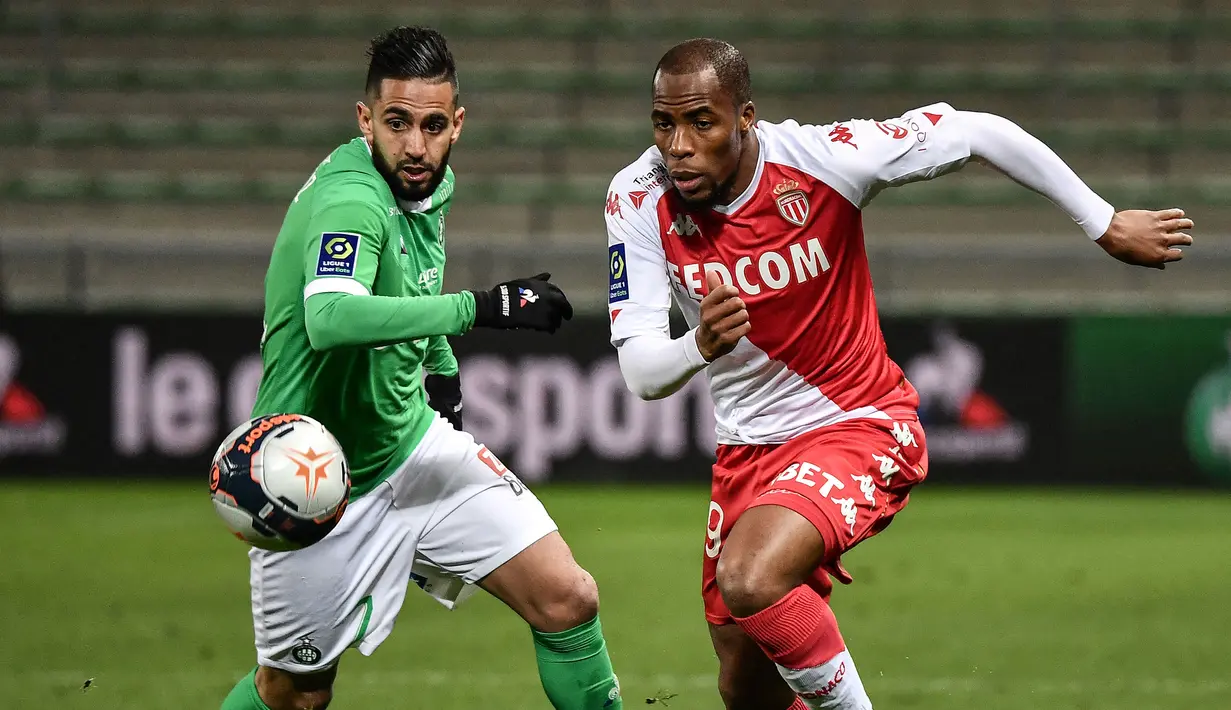 Bek AS Monaco, Djibril Sidibe (kanan) berebut bola dengan gelandang Saint-Etienne, Ryad Boudebouz dalam laga lanjutan Liga Prancis 2020/2021 pekan ke-30 di Geoffroy Guichard Stadium, Jumat (19/3/2021). Monaco menang 4-0 atas Saint-Etienne. (AFP/Jeff Pachoud)