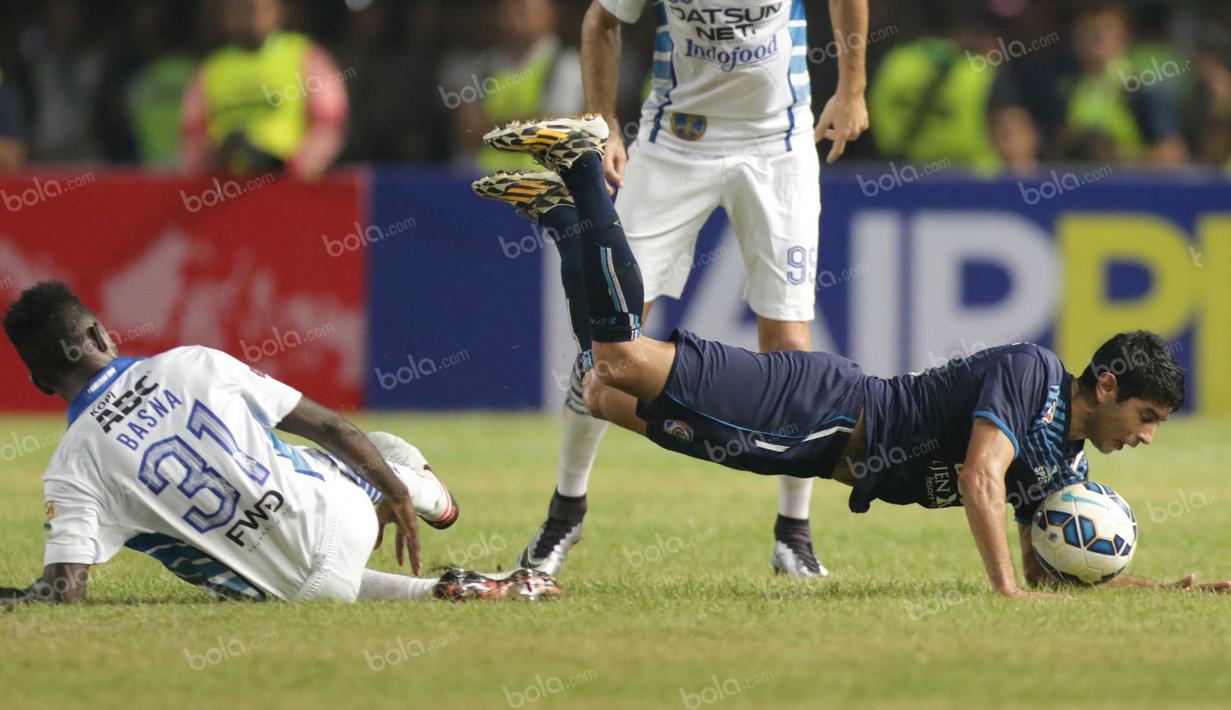 Pemain Arema Cronus, Esteban Vizcarra (kanan), harus jatuh bangun untuk melewati Yanto Basna pada laga final Torabika Bhayangkara Cup di SUGBK, Jakarta, Minggu (3/4/2016). (Bola.com/Nicklas Hanoatubun)