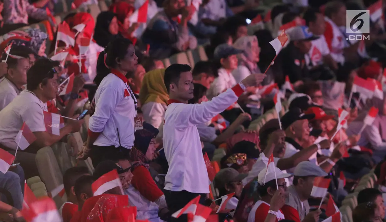 Sejumlah relawan pendukung mengibarkan bendera Merah Putih jelang menyaksikan pidato Visi Indonesia yang akan disampaikan Presiden/Wakil Presiden terpilih 2019-2024, Joko Widodo dan KH Ma’ruf Amin di SICC, Kab Bogor, Jawa Barat, Minggu (14/7/2019). (Liputan6.com/Helmi Fithriansyah)