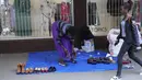 Pedagang kaki lima memajang sepatu baru dan bekas dengan harga murah di luar pintu masuk toko pakaian di jalanan Harare, dalam foto Senin, 22 Mei 2023 ini. (AP Photo/Tsvangirayi Mukwazhi)