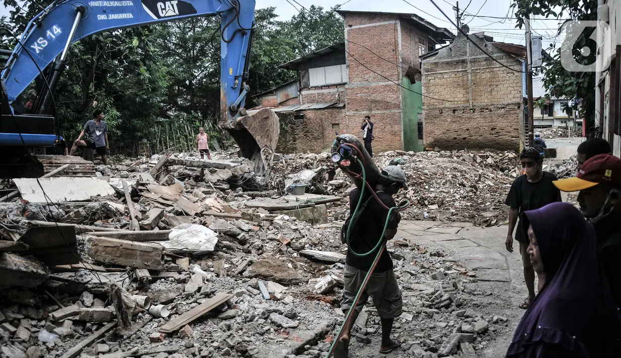 Warga menyaksikan petugas menggunakan kendaraan alat berat saat pembebasan lahan untuk proyek Normalisasi Ciliwung di Rawajati, Jakarta Selatan, Rabu (9/11/2022). Anggaran Normalisasi Ciliwung ini akan dialokasikan untuk pembebasan lahan dalam program pengendalian banjir. (merdeka.com/Iqbal S Nugroho)