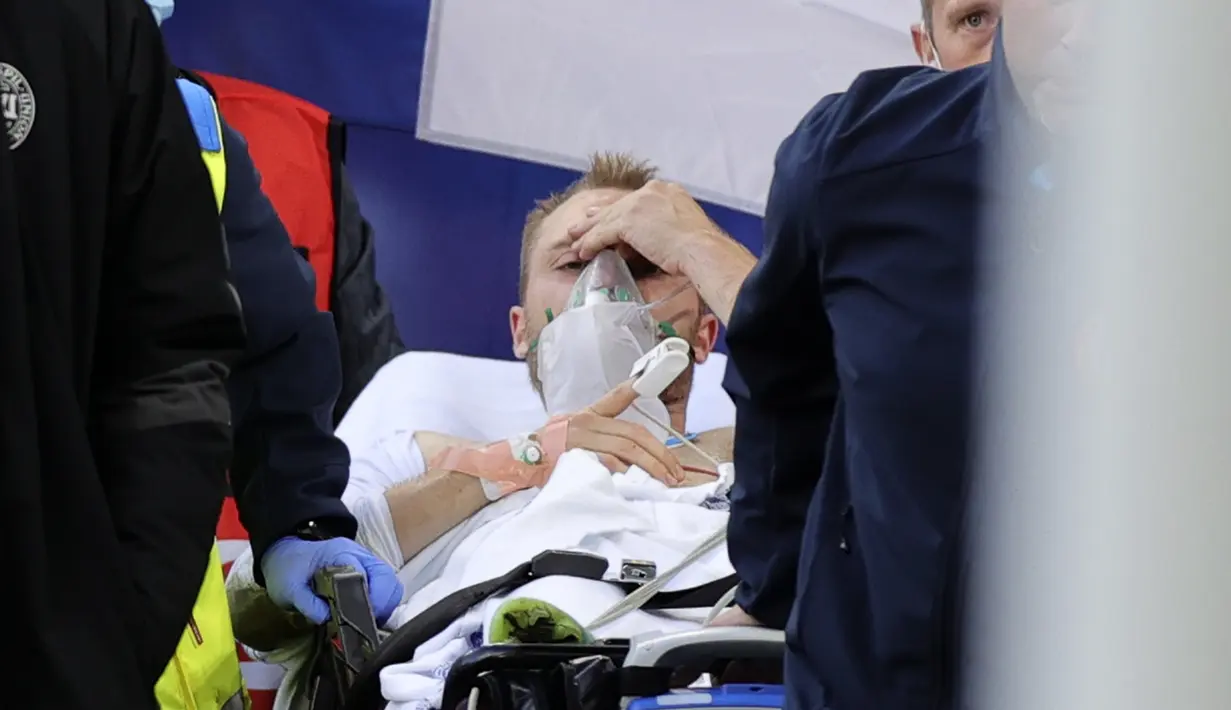 Paramedis menandu Christian Eriksen keluar dari lapangan setelah pingsan pada laga Denmark vs Finlandia di Grup B Euro 2020 di Parken Stadium, Sabtu (12/6/2021). Eriksen tiba-tiba terjatuh dan kehilangan kesadaran saat hendak menyambut lemparan ke dalam. (Friedemann Vogel/Pool via AP)