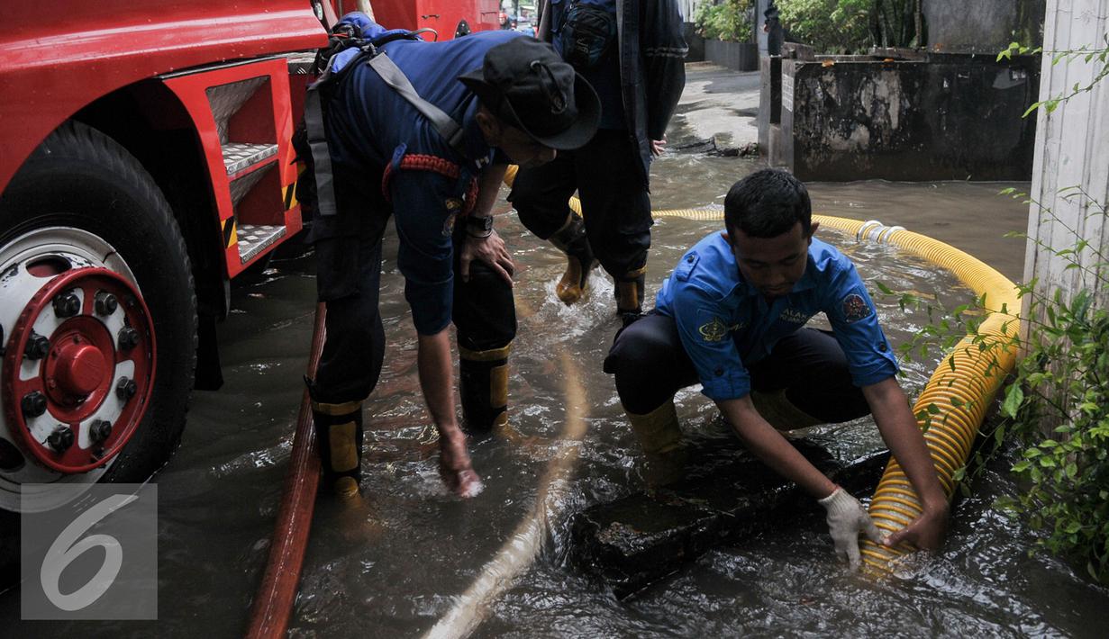 Petugas pemadam kebakaran (damkar) melakukan penyedotan genangan air di Pejaten Raya, Jakarta, Selasa (4/10). Akibat curah hujan yang tinggi menyebabkan sejumlah titik di Jakarta Selatan tergenang air. (Liputan6.com/Yoppy Renato)