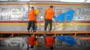 Seniman mural dan grafiti menggambar pada gerbong Kereta Rangkaian Listrik (KRL) Edukasi di Depo KRL, Depok, Jawa Barat, Kamis (29/8/2024). (merdeka.com/Arie Basuki)