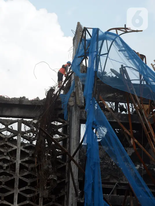 Pekerja membongkar bangunan Gedung Kejaksaan Agung setelah terbakar di Jakarta, Rabu (14/4/2021). Gedung utama Kejaksaan Agung mulai dibongkar setelah mengalami kebakaran pada 22 Agustus 2020. (merdeka.com/Imam Buhori)