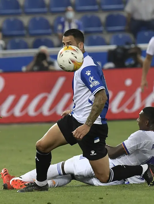 Gelandang Deportivo Alaves Edgar Alaves menghindari tekel bek Real Madrid David Alaba pada partai perdana La Liga Spanyol musim 2020/2021 di Estadio de Mendizorroza, Minggu dini hari WIB (15/8/2021). Real Madrid menang telak 4-1. (AP Photo/Alvaro Barrientos)