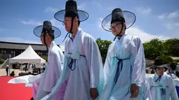 Para pria muda mengenakan pakaian tradisional untuk menghadiri upacara “Coming of Age” di Namsan Hanok Village, Seoul, Senin (20/5/2019). Di Korea Selatan, Coming of Age Day atau hari kedewasaan dirayakan secara nasional setiap tahun pada hari Senin ketiga di bulan Mei. (Ed JONES/AFP)