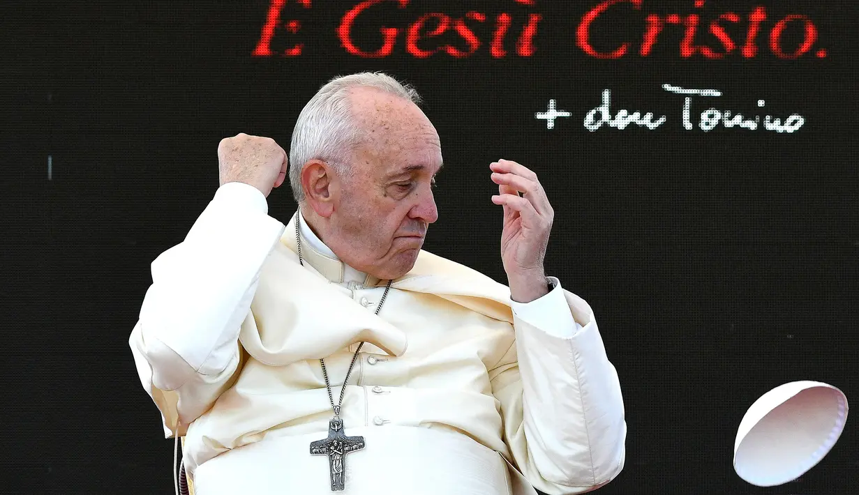 Zucchetto yang dikenakan Paus Fransiskus tertiup angin saat upacara peringatan 25 tahun kematian Don Tonino Bello di Alessano, Italia (20/4). Insiden ini ternyata bukan yang pertama terjadi, di mana angin menerbangkan peci Paus. (AFP/Vincenzo Pinto)