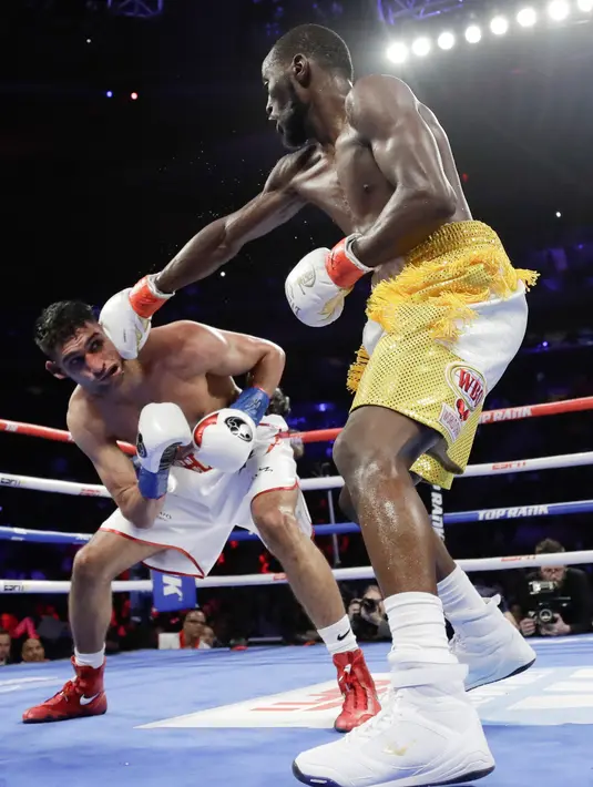 Terence Crawford (kanan) meninju Amir Khan pada perebutan gelar juara dunia tinju kelas welter WBO di Madion Square Garden, New York, Amerika Serikat, Minggu (21/4). Khan tidak mampu melanjutkan pertarungan. (AP Photo/Frank Franklin II)