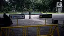 Petugas berjaga di dalam pembatas tulisan tanda ditutup sementara untuk mencegah penyebaran virus Covid-19 di Taman Suropati, Menteng, Jakarta, Senin (21/12/2020). (merdeka.com/Dwi Narwoko)