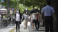 Orang-orang yang memakai masker melintasi persimpangan di Tokyo Kamis (5/8/2021). Tokyo pada hari Kamis melaporkan 5.042 kasus virus corona baru, rekor tertinggi harian terbaru sejak pandemi Covid-19 dimulai, di saat ibu kota Jepang menjadi tuan rumah Olimpiade. (AP Photo/Kantaro Komiya)