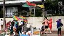 Payung milik pedagang terhembus angin kencang yang terjadi di sekitar Bundaran Hotel Indonesia, Jakarta, Minggu (26/11). Angin kencang dan gerimis terjadi saat kegiatan Hari Bebas Kendaraan, Minggu pagi. (Liputan6.com/Helmi Fithriansyah)