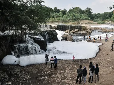 Wisatawan mengunjungi Curug Parigi yang tengah tercemar limbah busa di Cikiwul, Bantargebang, Bekasi, Jawa Barat, Minggu (19/7/2020). Destinasi wisata favorit warga Bekasi dan sekitarnya tercemar limbah sejak dua hari lalu sehingga menimbulkan busa dan bau tak sedap. (merdeka.com/Iqbal S. Nugroho)