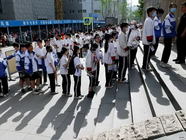 Siswa berbaris untuk masuk sekolah pada hari pertama ujian masuk perguruan tinggi nasional yang dikenal sebagai gaokao di Beijing, China, Rabu (7/6/2023). (WANG Zhao/AFP)