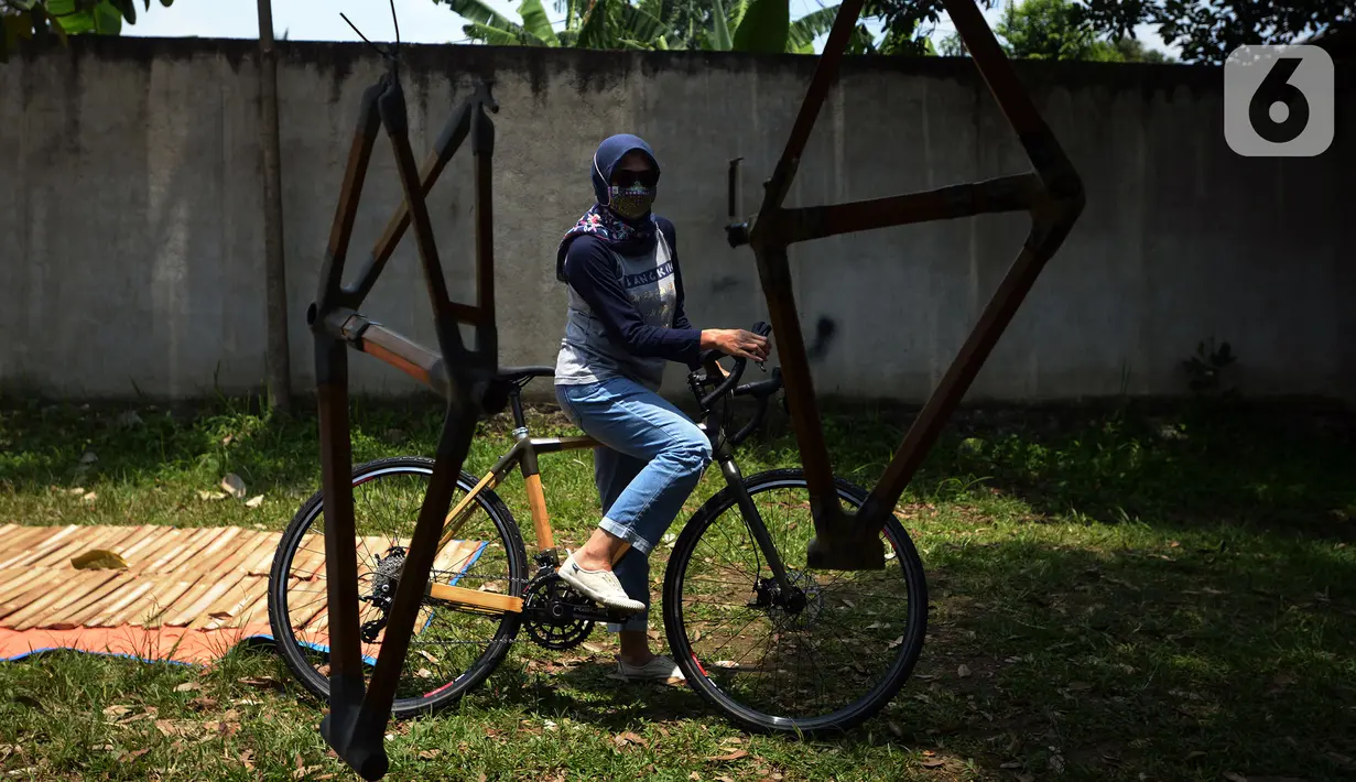 Pemilik workshop Arana Bike Deny Hesti menaiki sepeda yang terbuat dari bambu di kawasan Gunung Putri, Kabupaten Bogor, Jawa Barat, Selasa (15/3/2022). Selama pandemi, Arana Bike memproduksi dua tipe yakni Komodo dan Minivelo yang semua rangka sepedanya terbuat dari bambu. (merdeka.com/Imam Buhori)