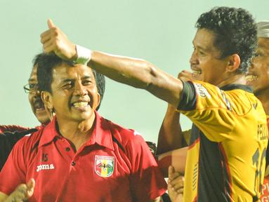 Pelatih Mitra Kukar, Jafri Sastra (kiri) merayakan kemenangan atas Arema Cronus bersama Rizki Pellu di Stadion Kanjuruhan, Kabupaten Malang, Minggu (17/1/2016). (Bola.com/Kevin Setiawan)