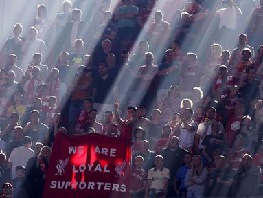 Sejumlah suporter Liverpool dengan bermandikan cahaya saat menyaksikan laga melawan Chelsea pada final Piala FA di Stadion Wembley. (AP/Ian Walton)