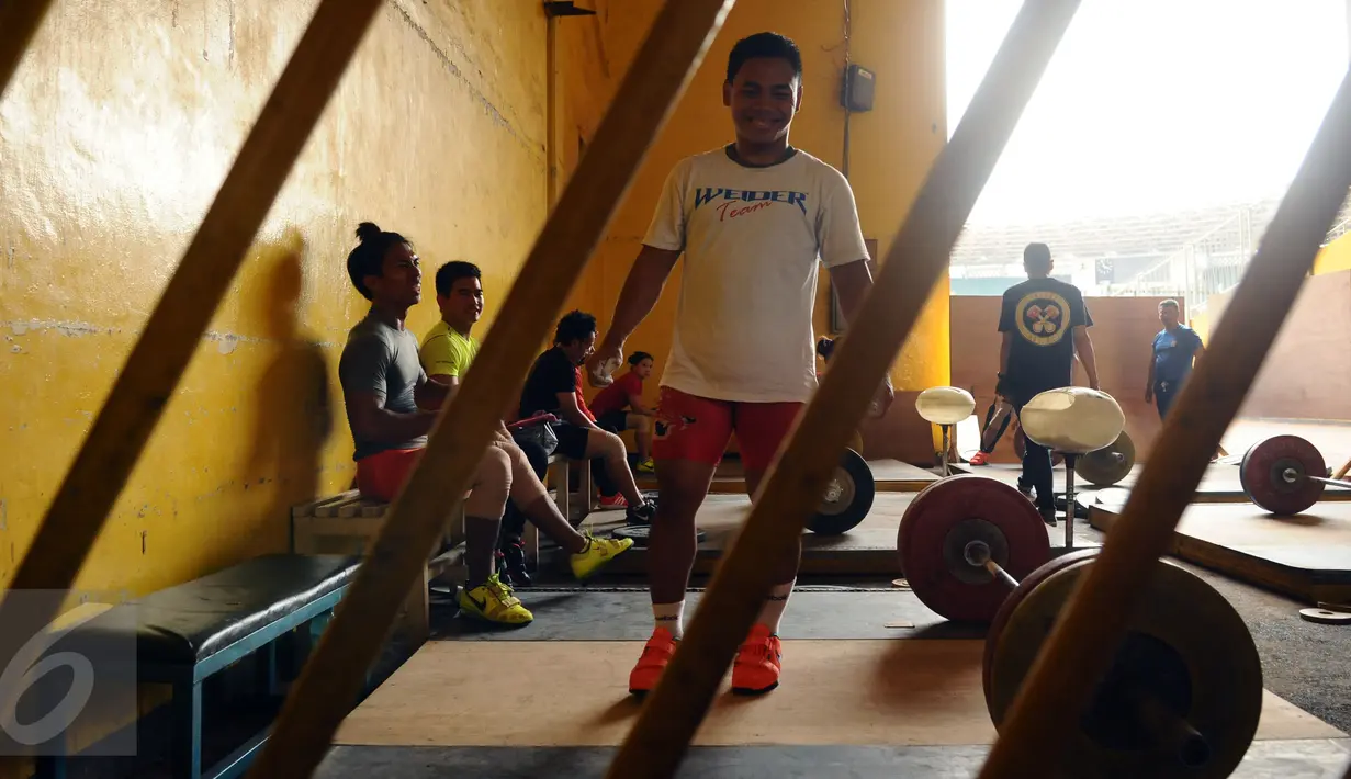 Lifter Indonesia, Eko Yuli Irawan bersiap melakukan angkatan saat latihan di luar gedung PB PABBSI, Stadion GBK Jakarta, Senin (11/1/2016). Latihan dilakukan diluar gedung akibat proses renovasi gedung PB PABBSI. (Liputan6.com/Helmi Fithriansyah)
