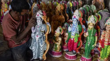 Seorang seniman India mewarnai patung dewa Hindu Rama di sebuah lokakarya di Hyderabad, India (15/3). Para seniman ini membuat patung dewa menjelang festival Rama Navami. (AFP/Noah Seelam)