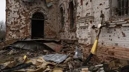 Sebuah salib logam yang dulunya berada di atas kubah berdiri di luar gereja yang rusak di Lukashivka, di Ukraina utara, 22 April 2022. Penduduk mengatakan tentara Rusia menggunakan rumah ibadah untuk menyimpan amunisi, dan pasukan Ukraina menembaki gedung itu untuk membuat Rusia pergi. (AP Photo/Petros Giannakouris)