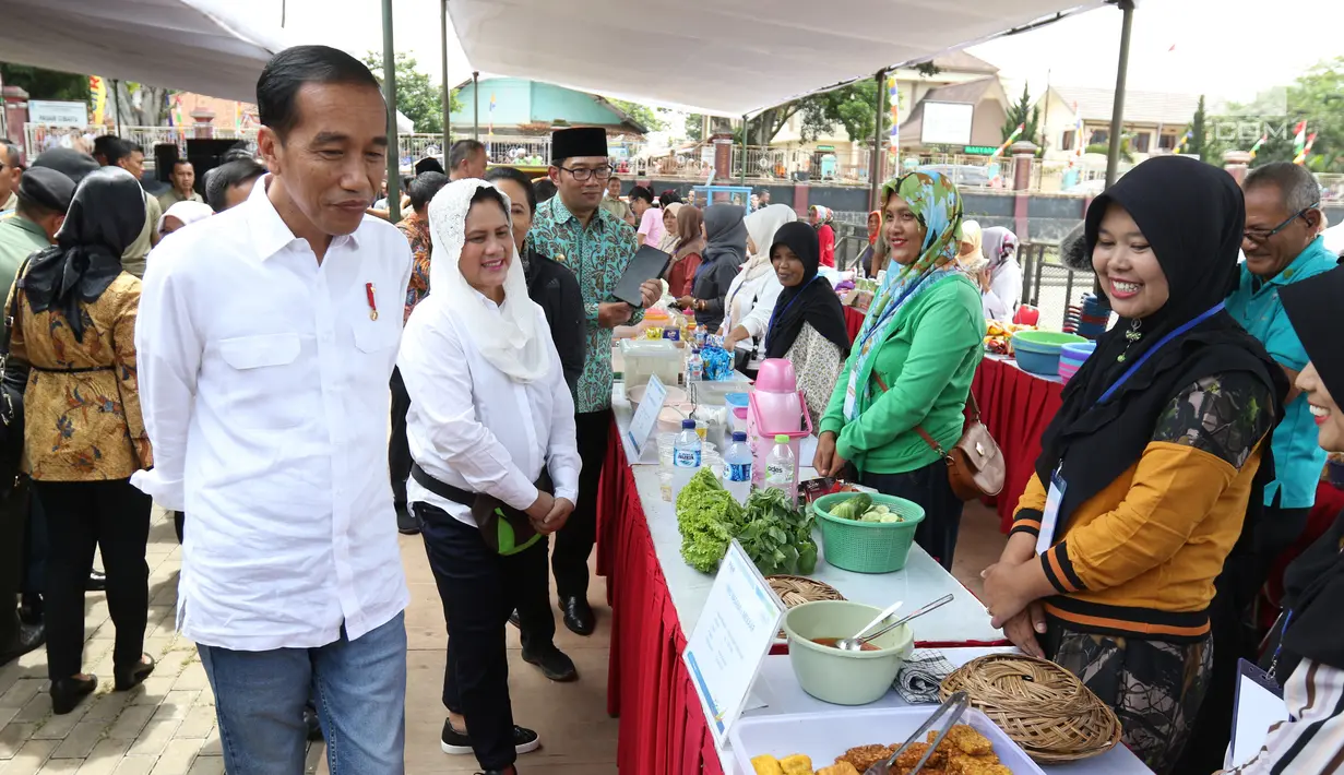 Presiden Joko Widodo bersama Ibu Negara Iriana menemui ibu-ibu penerima program Membina Keluarga Sejahtera (Mekaar) di Garut, Jawa Barat, Jumat (18/1). Jokowi meminta penerima program Mekaar semangat menjalankan roda bisnis. (Liputan6.com/Angga Yuniar)