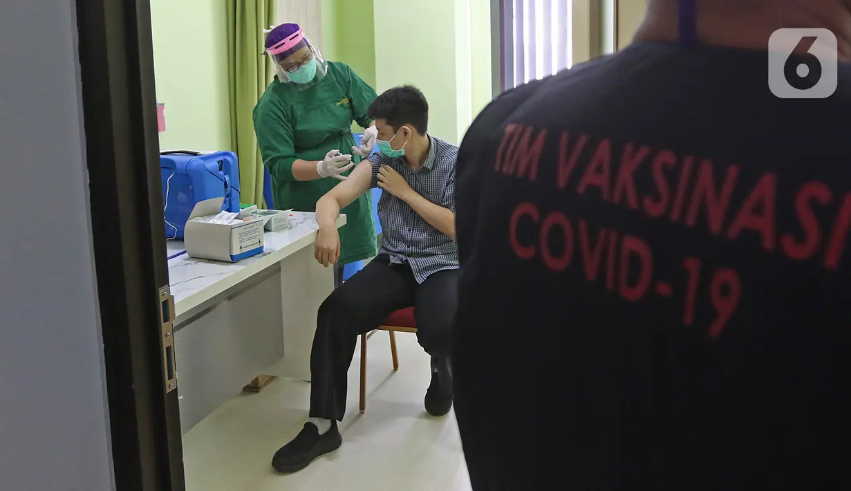 Petugas vaksinator menyuntikkan vaksinasi COVID-19 kepada tenaga kesehatan di RSUD Cengkareng, Jakarta, Kamis (14/01/2021). RSUD Cengkareng melakukan vaksinasi Covid-19 untuk para tenaga medis dan tenaga kesehatan yang bertugas. (Liputan6.com/Herman Zakharia)