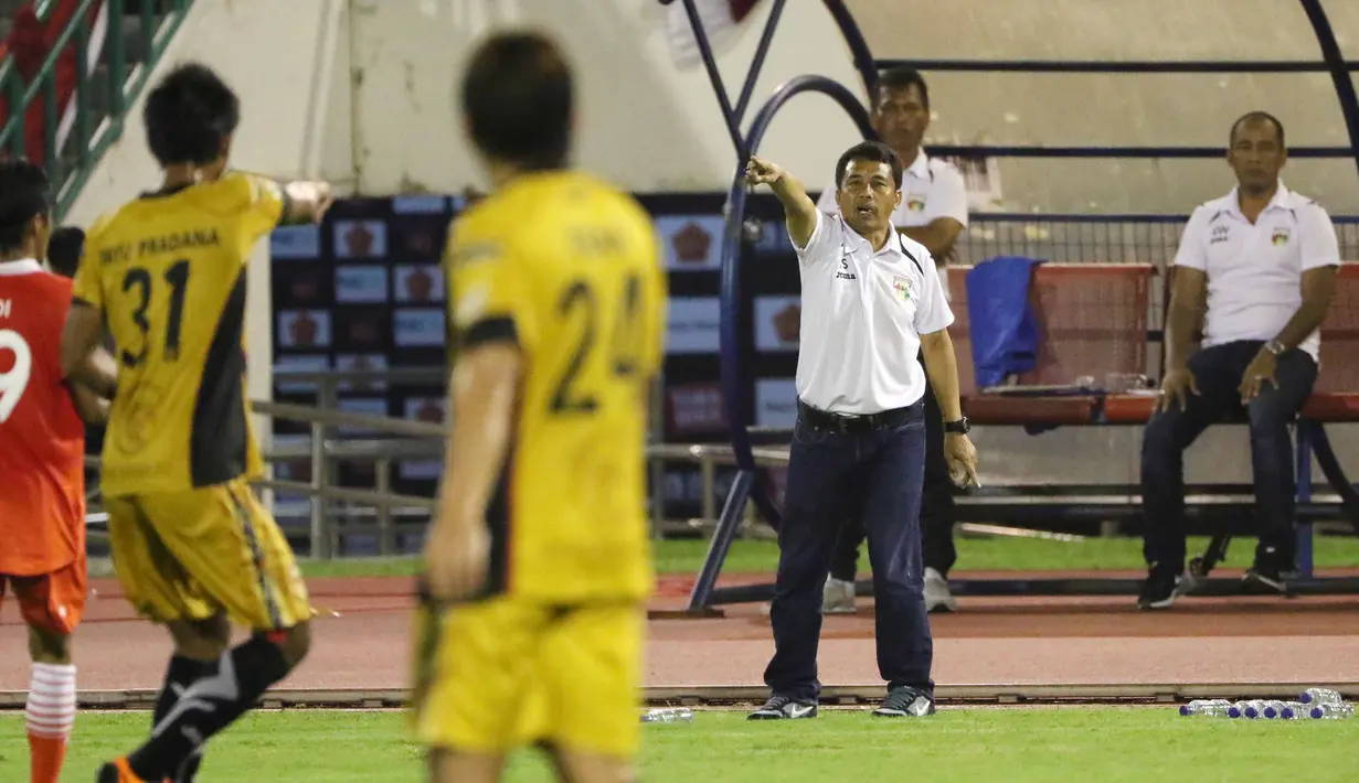 Pelatih Mitra Kukar, Jafri Sastra (2kanan) memberikan Instruksi kepada para pemainnya Pada laga Piala Jenderal Sudirman grup D di Stadion Manahan, Solo, Sabtu (12/12/2015). (Bola.com/Nicklas Hanoatubun)