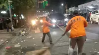 Petugas membersihkan sampah bekas acara Surabaya Vaganza. (Dian Kurniawan/Liputan6.com).
