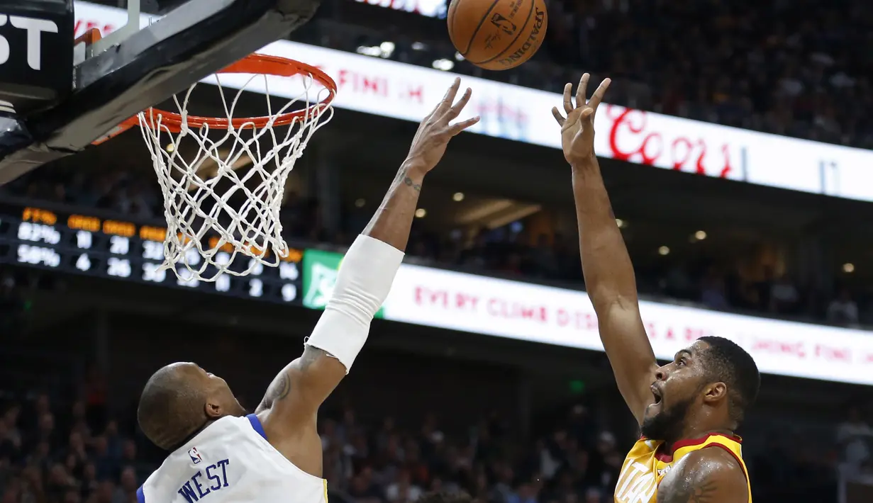 Pemain Utah Jazz,  Derrick Favors (kanan) berusaha menghalau tembakan pemain Warriors, David West pada lanjutan NBA basketball game di Vivint Smart Home Arena, Salt Lake City, (30/1/2018). Utah menang 129-99. (AP/Rick Bowmer)
