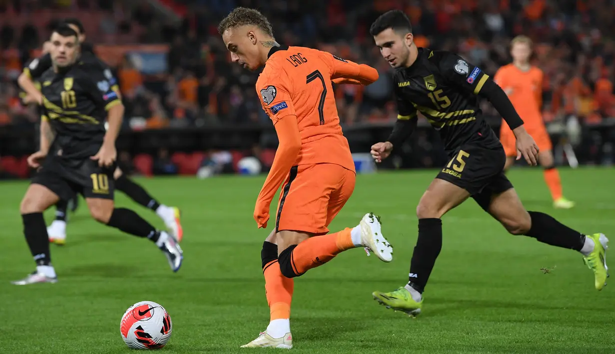 Pemain depan Belanda Noa Lang (depan) berebut bola dengan bek Gibraltar Julian Valarino pada laga Kualifikasi Piala Dunia 2022 zona Eropa Grup G di De Kuip, Rotterdam, Selasa (12/10/2021) dini hari WIB. Menjamu Gibraltar, Belanda menang 6 gol tanpa balas. (JOHN THYS/AFP)