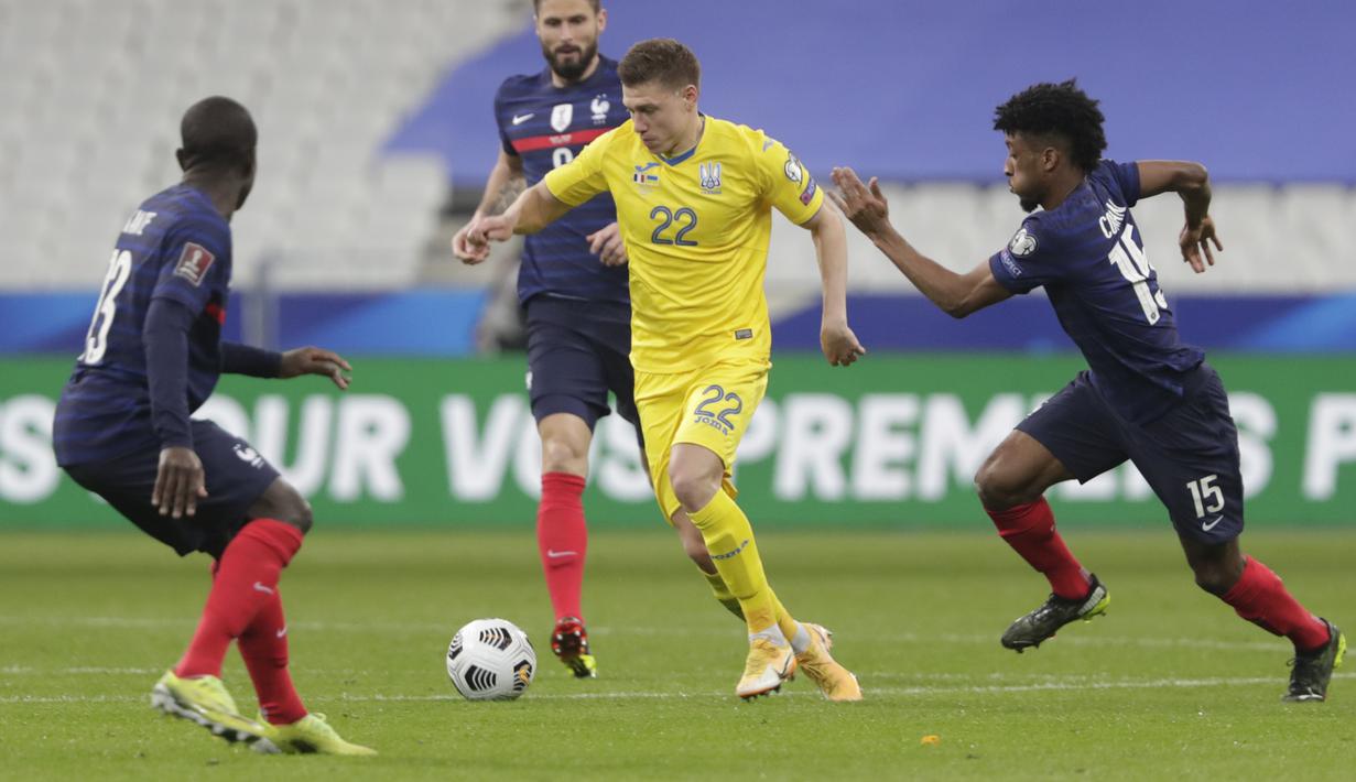 Bek Ukraina, Mykola Matviyenko membawa bola dari kejaran pemain Prancis, Kingsley Coman pada pertandingan kualifikasi Piala Dunia D di stadion Start de France, di Saint Denis, utara Paris, Kamis (25/3/2021). Prancis bermain imbang atas Ukraina 1-1. (AP Photo/Thibault Camus)
