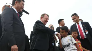 Seorang anak bersalaman dengan PM Denmark Lars Lokke Rasmussen didampingi Menko Kemaritiman, Luhut Pandjaitan di bantaran sungai belakang Museum Bahari, Jakarta, (28/11). Kedatangannya guna mendukung agenda kelautan Indonesia. (Liputan6.com/Angga Yuniar)