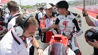 Mario Suryo Aji jelang balapan Moto2 Mandalika. Tampak ia berbincang dengan Somkiat Chantra. (Honda Team Asia)