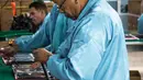 Teknisi wanita menyelesaikan proses perakitan tablet PC berteknologi Haier China di Gedeme, Havana, Kuba (15/5). Kuba-China menjalani kemitraan dalam bidang industri elektronik komputer. (AFP Photo/Adalberto Roque)