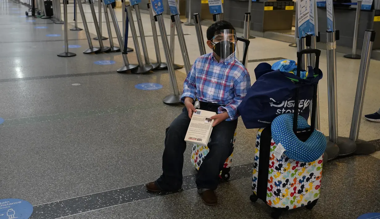 Alejandro Zelaya, 10, menunggu check-in untuk penerbangannya ke El Salvador di Bandara Internasional Los Angeles, 23 November 2020. Sekitar 1 juta orang Amerika memadati bandara dan pesawat menjelang libur Thanksgiving pekan ini bahkan saat kematian akibat COVID-19 melonjak. (AP Photo/Jae C. Hong)