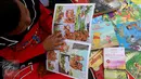 Seorang anak membaca buku di Kawasan Bundaran HI saat berlangsungnya Hari Bebas Kendaraan Bermotor, Jakarta, Minggu (2/4). Kegiatan ini dilakukan sebagai ajakan kampanye "Budayakan Membaca dari Desa untuk Indonesia". (Liputan6.com/Johan Tallo)