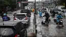 Warga mendorong sepeda motornya saat menerobos banjir di jalan depan Ancol, Jakarta, Kamis (21/4). Hujan deras yang mengguyur sejak semalam menyebabkan beberapa kawasan di Jakarta tergenang banjir. (Liputan6.com/Faizal Fanani)